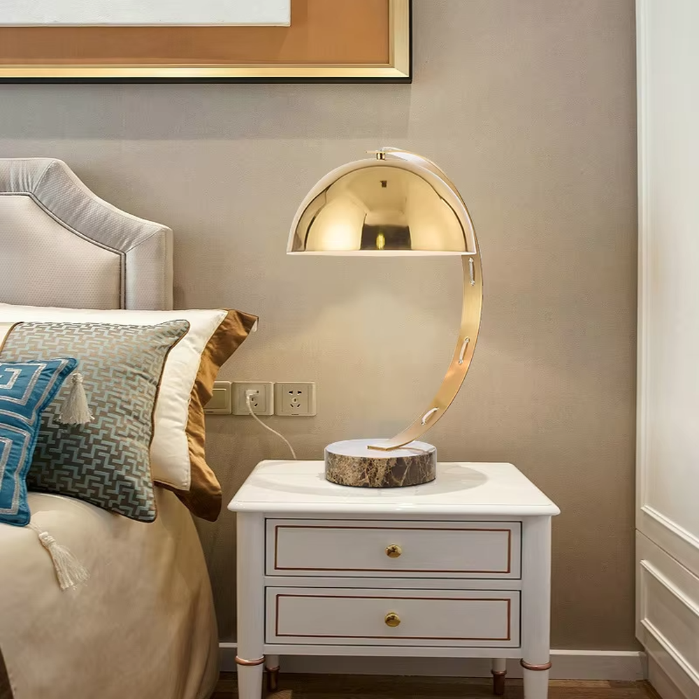 Light luxury golden curved hemisphere table lamp, marble-patterned round base, soft and warm lighting, creating a high-end elegant space atmosphere.