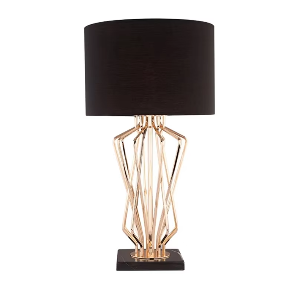 Light luxury golden interlaced hollow table lamp, white cylindrical fabric lampshade + black base, soft and warm lighting, creating a high-end elegant atmosphere.