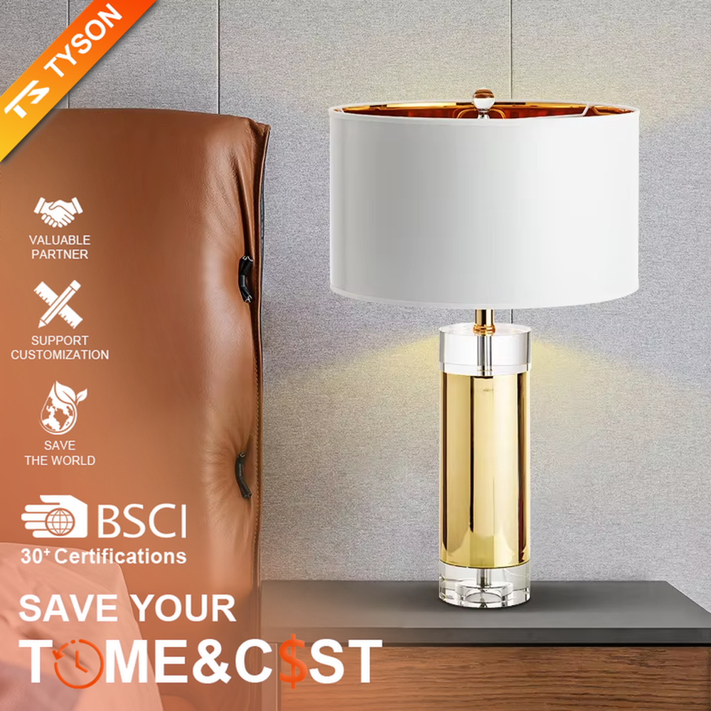 This is a luxury metal crystal table lamp, with a golden metal column, a transparent crystal base, and a white cylindrical fabric lampshade (with golden decoration on top), featuring a luxurious and elegant design with strong modern sense. It is used for local desktop lighting and decoration, creating a high-end luxury atmosphere. It is suitable for luxury-style home bedroom bedside tables, high-end hotel guest rooms, modern soft decoration display spaces and other places.