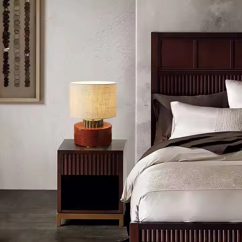 This is a modern artistic green and gold table lamp, with a green textured base, golden metal ring, and beige fabric circular lampshade, featuring a minimalist and grand design with both artistic sense and texture. It is used for local desktop lighting and decoration, creating a modern artistic atmosphere. It is suitable for modern minimalist home bedroom bedside tables, artistic-style living room side tables, high-end hotel guest rooms and other places.