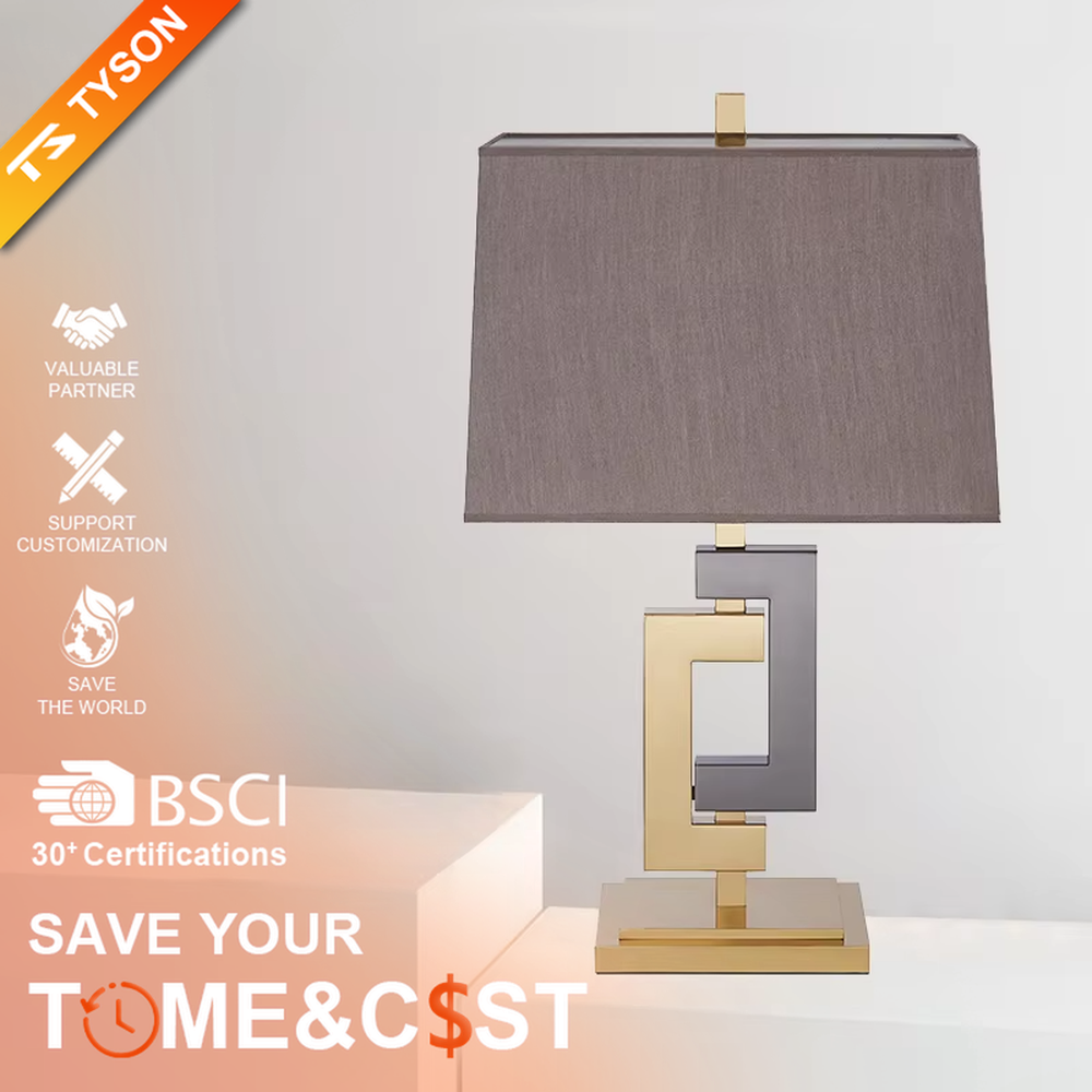 Light luxury gold-gray color-blocking geometric square frame table lamp, gold + dark gray metal geometric stand + dark gray fabric rectangular lampshade, soft and high-end lighting, creating a light luxury modern atmosphere.