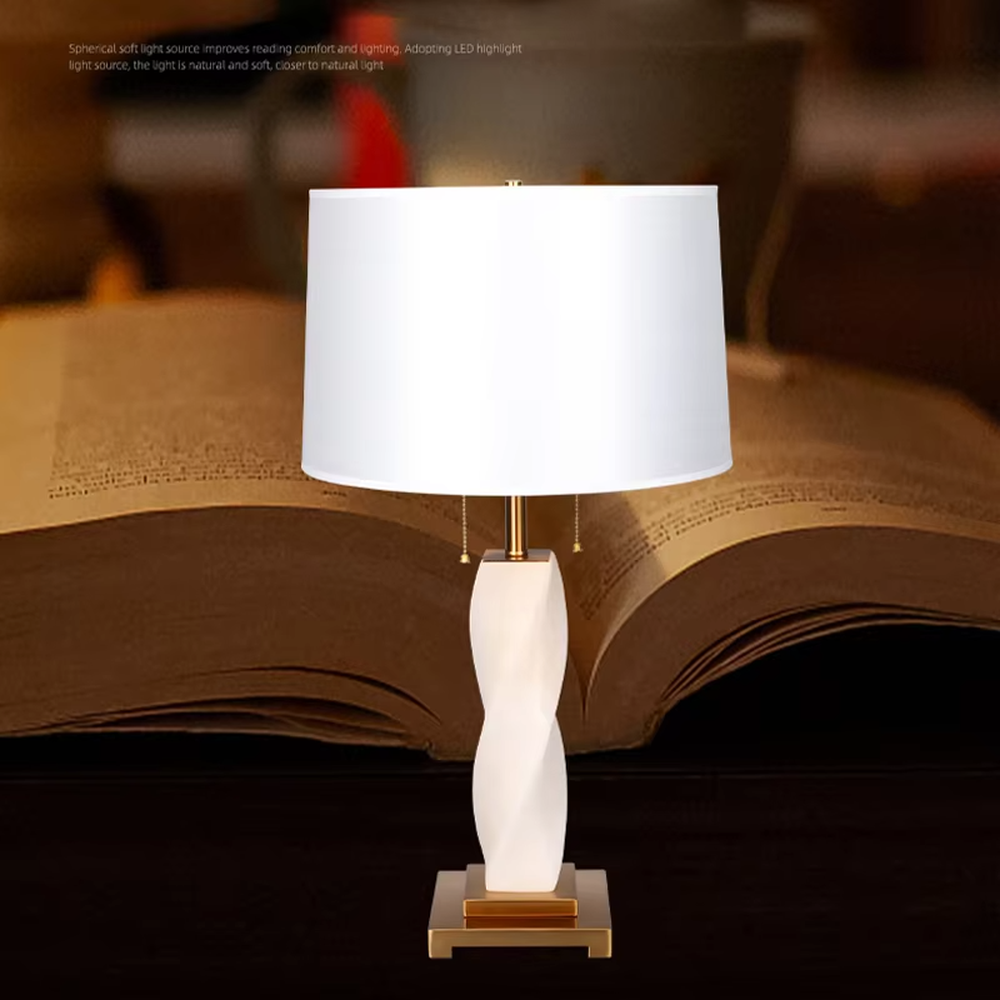 This is a modern artistic twisted table lamp, with a white twisted base, golden metal components, and a white fabric circular lampshade, featuring a strong artistic sense and luxury texture. It is used for local desktop lighting and decoration, creating an artistic luxury atmosphere. It is suitable for modern art home bedroom bedside tables, designer studios, high-end hotel guest rooms and other places.