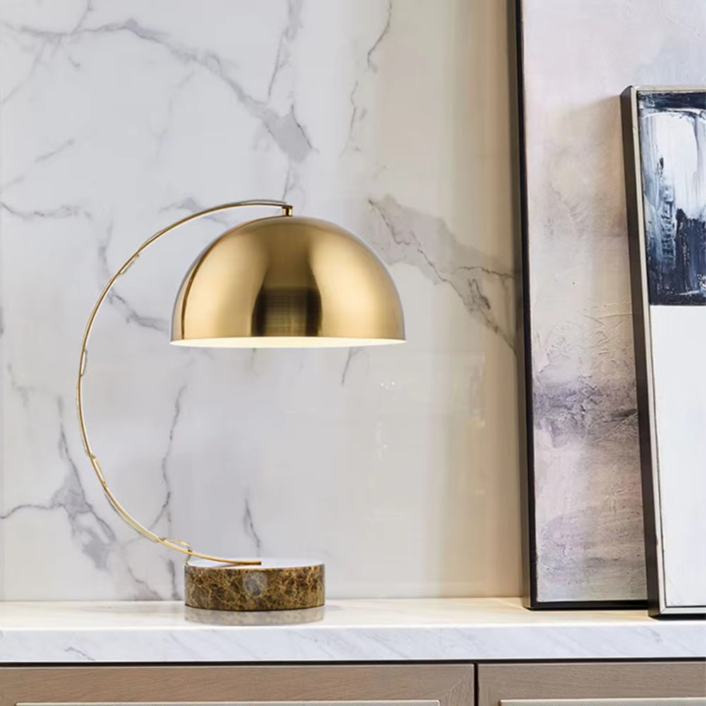 Light luxury golden curved hemisphere table lamp, marble-patterned round base, soft and warm lighting, creating a high-end elegant space atmosphere.