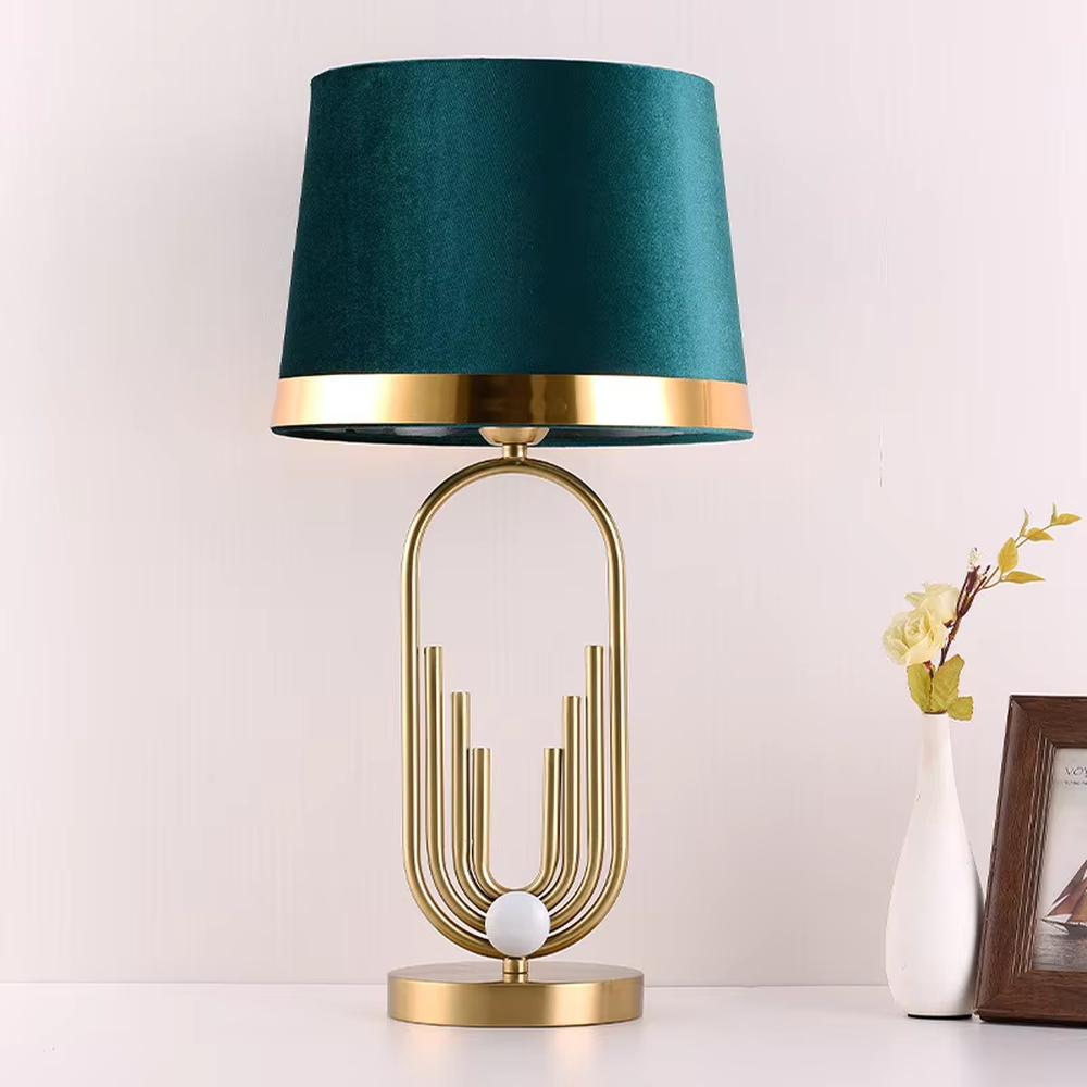 Light luxury golden geometric line base table lamp, beige fabric gold-edged lampshade + golden U-shaped multi-layer frame + white small ball decoration, soft warm light, creating a modern light luxury atmosphere.