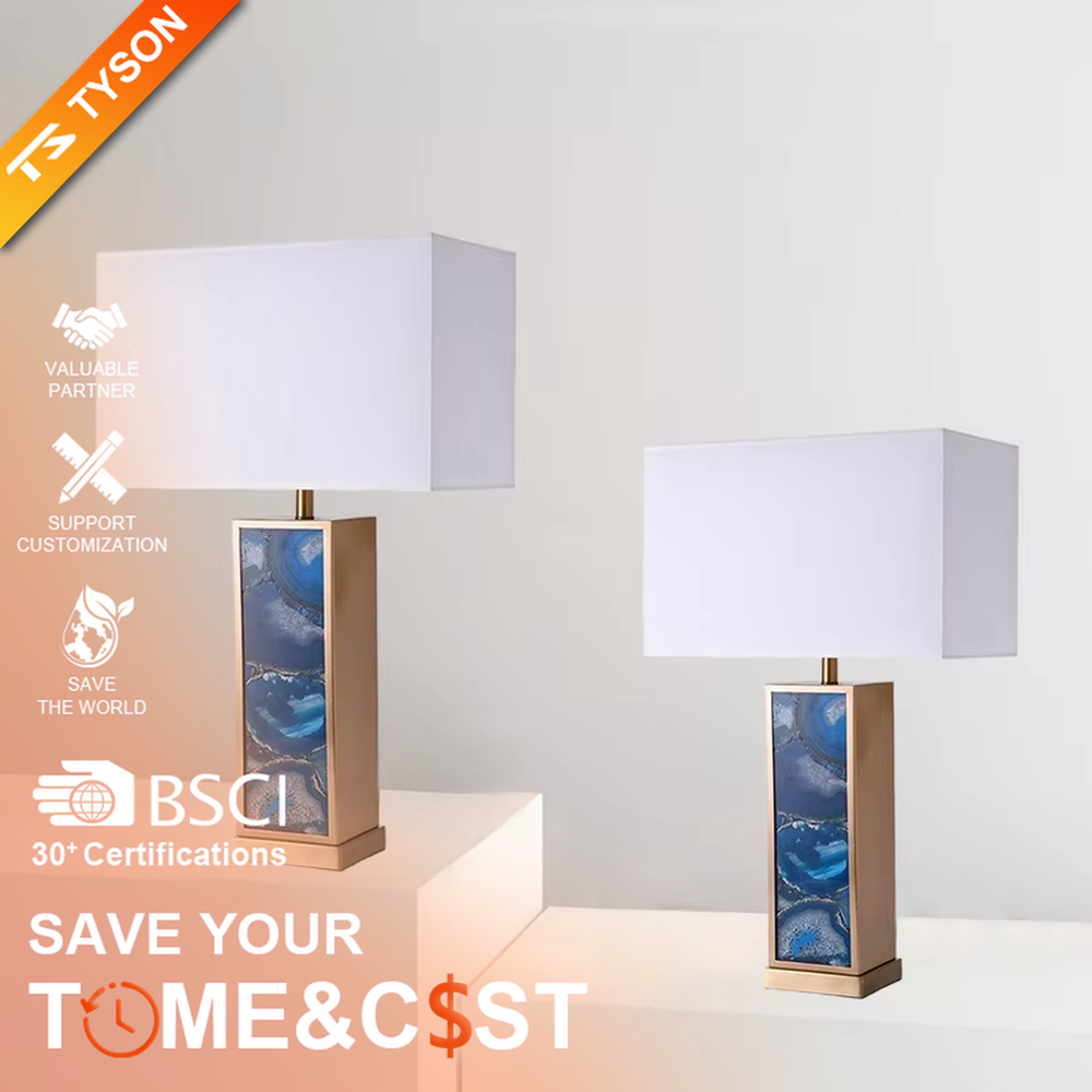 This is a luxury artistic agate-textured table lamp, with a golden metal frame inlaid with blue agate texture decoration and a white square fabric lampshade, featuring a minimalist and grand design with both artistic sense and luxury texture. It is used for local desktop lighting and decoration, creating a luxury artistic atmosphere. It is suitable for luxury-style home bedroom bedside tables, high-end hotel guest rooms, art exhibition hall display tables and other places.