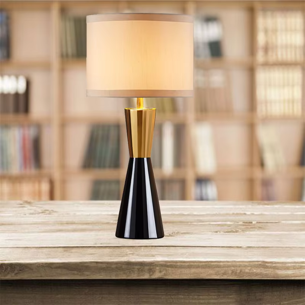 This is a light luxury black-gold cone table lamp, with a black cone base paired with golden decorations, a beige cylindrical lampshade with golden trim, soft and warm lighting, creating an elegant light luxury atmosphere.