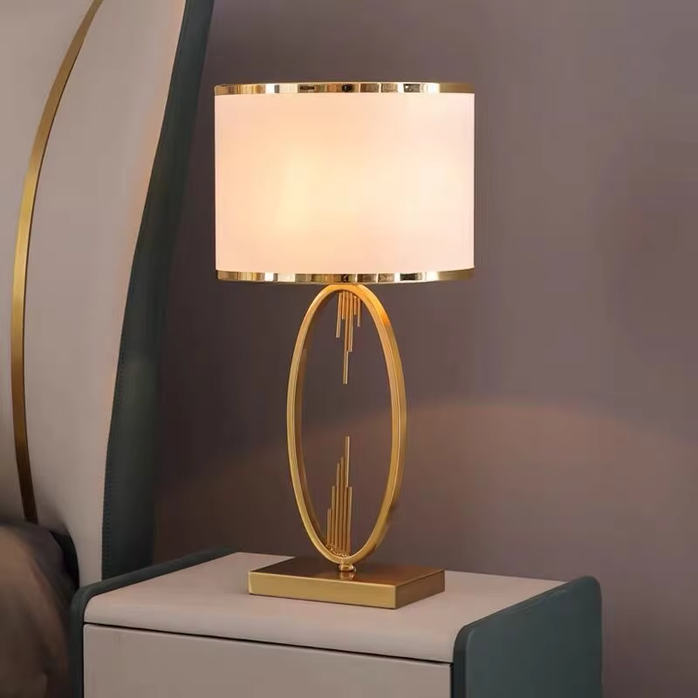 Light luxury golden geometric line base table lamp, beige fabric gold-edged lampshade + golden U-shaped multi-layer frame + white small ball decoration, soft warm light, creating a modern light luxury atmosphere.