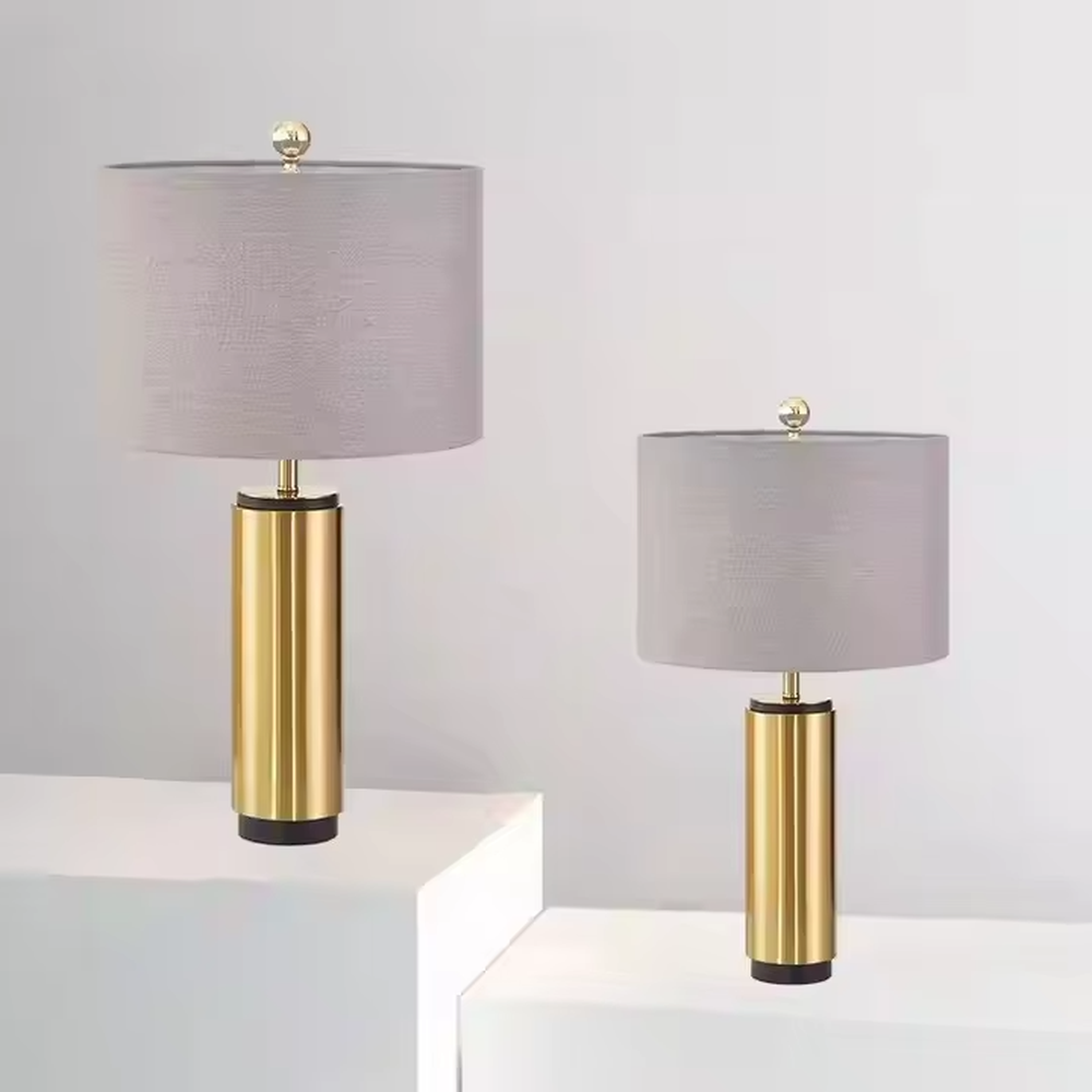 This is a luxury-style gold and gray table lamp, with a golden cylindrical base and a gray fabric circular lampshade, featuring a minimalist and grand design with strong luxury texture. It is used for local desktop lighting and decoration, creating a luxury and modern atmosphere. It is suitable for luxury-style home bedroom bedside tables, high-end hotel guest rooms, modern minimalist living room side tables and other places.
