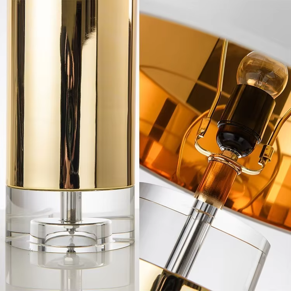 This is a luxury metal crystal table lamp, with a golden metal column, a transparent crystal base, and a white cylindrical fabric lampshade (with golden decoration on top), featuring a luxurious and elegant design with strong modern sense. It is used for local desktop lighting and decoration, creating a high-end luxury atmosphere. It is suitable for luxury-style home bedroom bedside tables, high-end hotel guest rooms, modern soft decoration display spaces and other places.