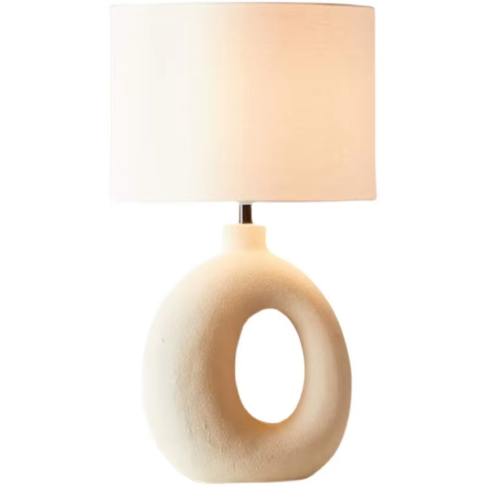 This is a modern artistic white hollow curved table lamp, with a white curved base (featuring a middle hollow design) paired with a white cylindrical lampshade. It has a minimalist artistic style and soft warm lighting.