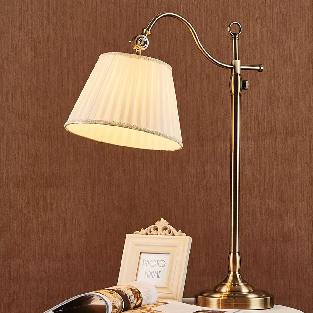 This is a retro European-style brass fabric table lamp, with a brass metal structure (with an adjustable curved arm and decorative details) and a beige pleated fabric lampshade. It features an exquisite retro design and soft warm lighting. It is used for local desktop lighting and decoration, creating a retro and warm atmosphere. Suitable for European-style bedrooms, studies, retro-style living rooms and other places.