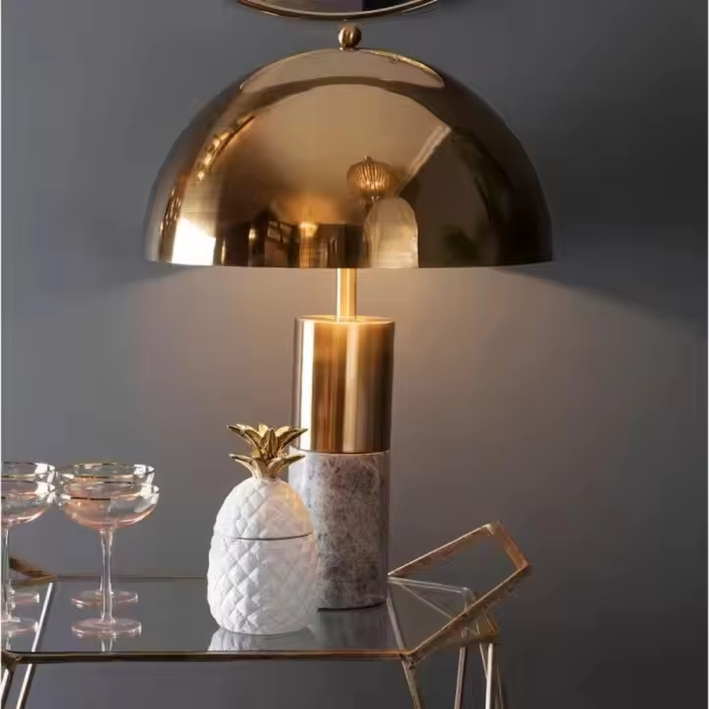 This is a luxury-style gold-brown marble table lamp, with a golden dome lampshade, golden metal pole, and brown marble base, featuring a minimalist and grand design with strong luxury texture. It is used for local desktop lighting and decoration, creating a luxury and modern atmosphere. Suitable for luxury-style home bedroom bedside tables, high-end hotel guest rooms, modern minimalist living room side tables and other places.