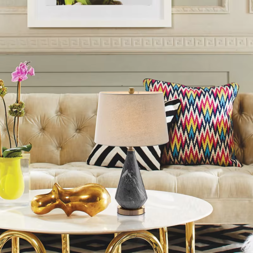 This is a light luxury marble-patterned cone table lamp, with a white fabric lampshade paired with a black-gray-white textured cone base, decorated with a golden metal base at the bottom and a small golden ball at the top. The lighting is soft and warm, creating an elegant light luxury atmosphere.