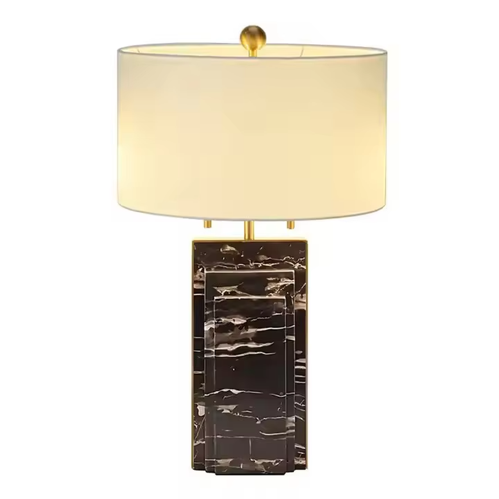 This is a luxury-style black-gold marble table lamp, with a black marble-textured base, golden metal parts, and a beige fabric circular lampshade, featuring a minimalist and grand design with strong luxury texture. It is used for local desktop lighting and decoration, creating a luxury and modern atmosphere. It is suitable for luxury-style home bedroom bedside tables, high-end hotel guest rooms, modern minimalist living room side tables and other places.