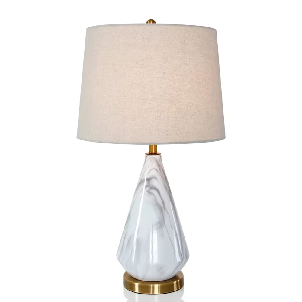 This is a light luxury marble-patterned cone table lamp, with a white fabric lampshade paired with a black-gray-white textured cone base, decorated with a golden metal base at the bottom and a small golden ball at the top. The lighting is soft and warm, creating an elegant light luxury atmosphere.