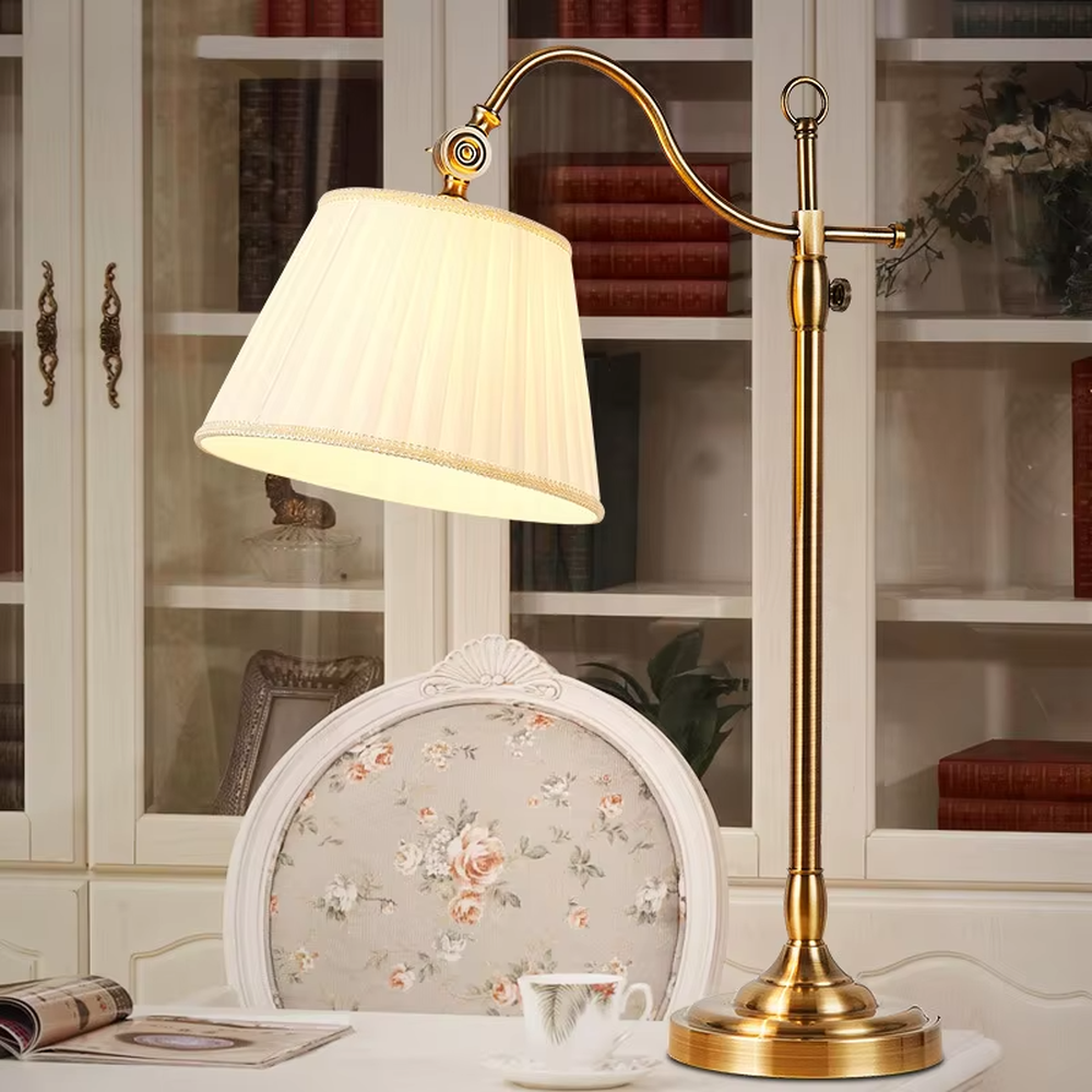This is a retro European-style brass fabric table lamp, with a brass metal structure (with an adjustable curved arm and decorative details) and a beige pleated fabric lampshade. It features an exquisite retro design and soft warm lighting. It is used for local desktop lighting and decoration, creating a retro and warm atmosphere. Suitable for European-style bedrooms, studies, retro-style living rooms and other places.