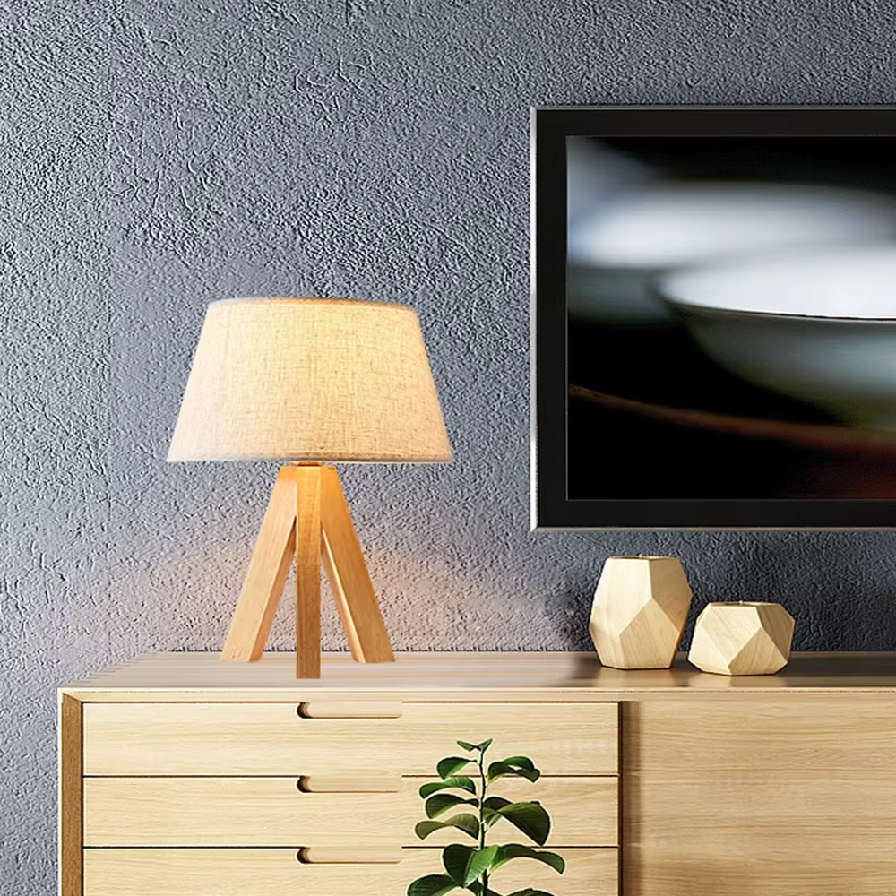 Natural minimalist-style wooden tripod table lamp, beige linen lampshade + solid wood stand, soft and warm lighting, creating a comfortable natural atmosphere.