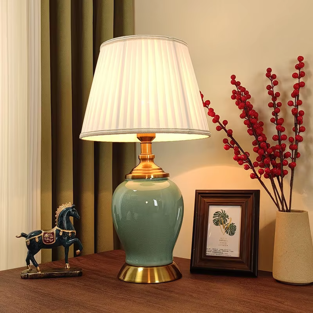 Vintage elegant-style beige pleated fabric lampshade table lamp, white porcelain vase base + golden metal decorations, soft and warm lighting, creating an elegant and cozy atmosphere.