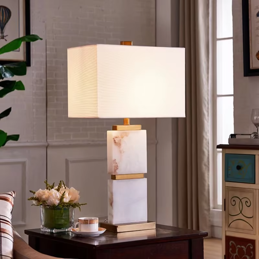 Light luxury dark green marble gold-decor light cyan fabric lampshade table lamp, square marble base + golden decorative strips + light cyan fabric lampshade, soft light, creating a high-end light luxury atmosphere.
