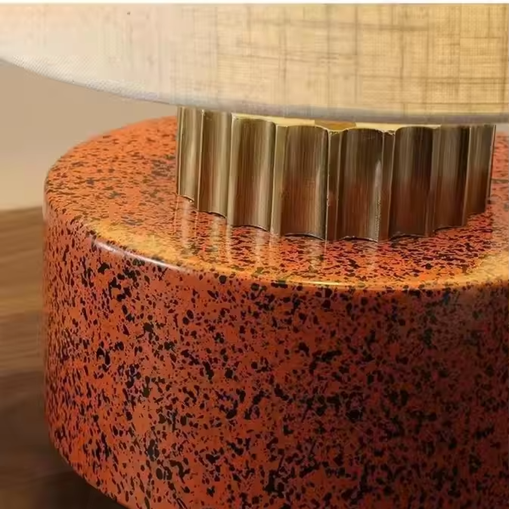 This is a modern artistic green and gold table lamp, with a green textured base, golden metal ring, and beige fabric circular lampshade, featuring a minimalist and grand design with both artistic sense and texture. It is used for local desktop lighting and decoration, creating a modern artistic atmosphere. It is suitable for modern minimalist home bedroom bedside tables, artistic-style living room side tables, high-end hotel guest rooms and other places.