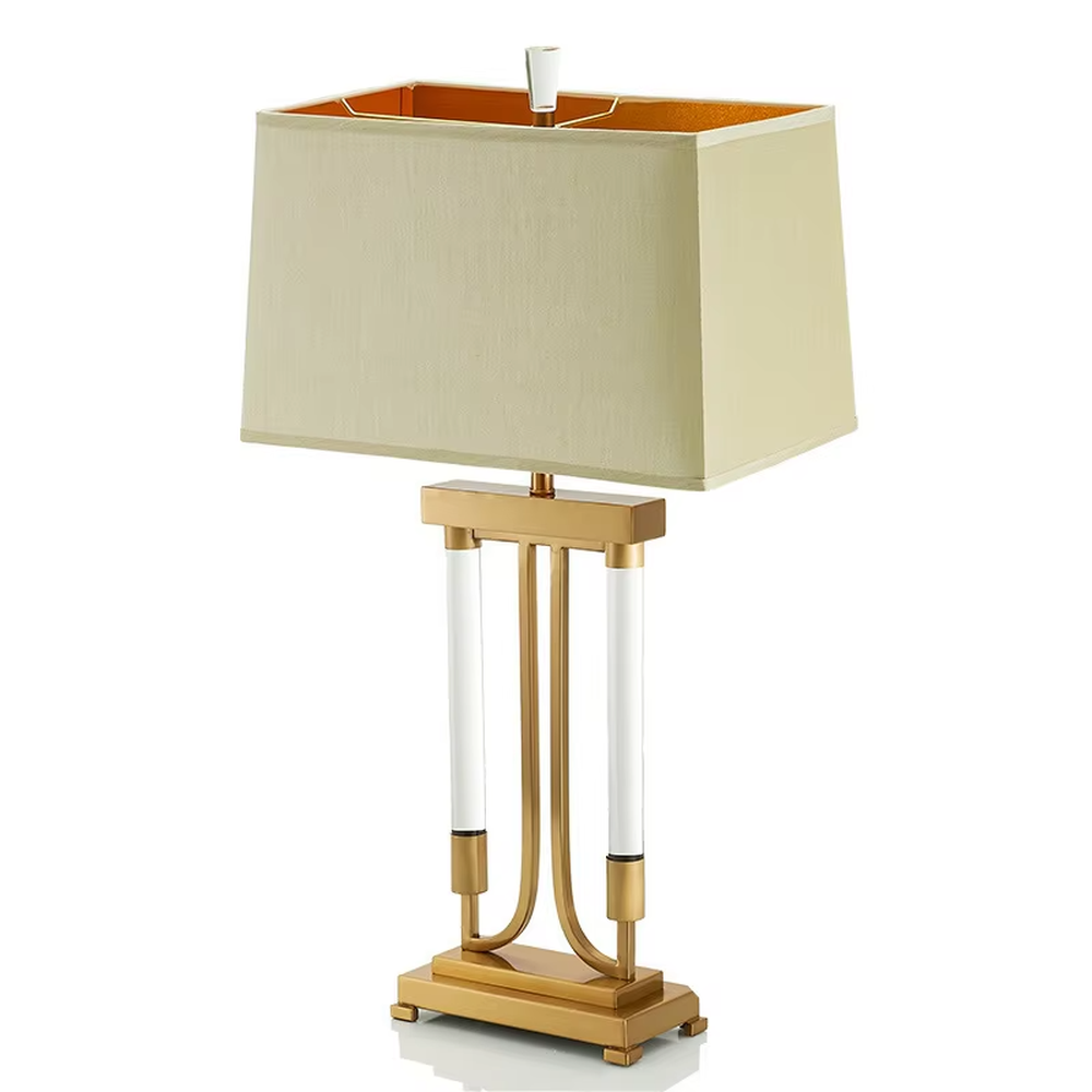This is a retro elegant-style gold and white fabric table lamp, with a golden metal bracket (with white column elements) and a beige fabric square lampshade (orange interior). It features a retro and exquisite design, with warm and soft lighting. It is used for local desktop lighting and decoration, creating a retro and elegant atmosphere. Suitable for retro-style bedrooms, European-style living rooms, high-end homestays and other places.