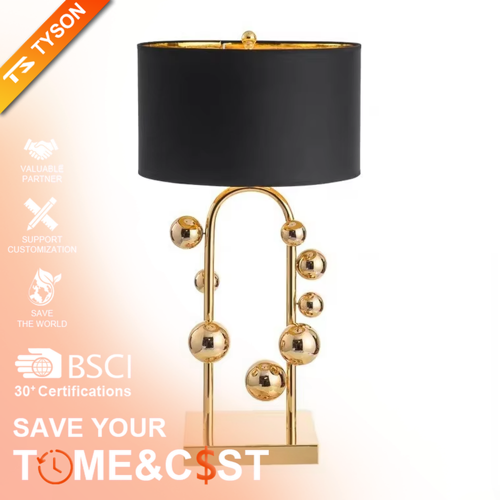 This is a light luxury modern-style golden ball table lamp, with a golden metal frame paired with multi-sized golden ball decorations, a black cylindrical lampshade + a golden square base, featuring a high-end and exquisite style, with soft and stylish lighting.