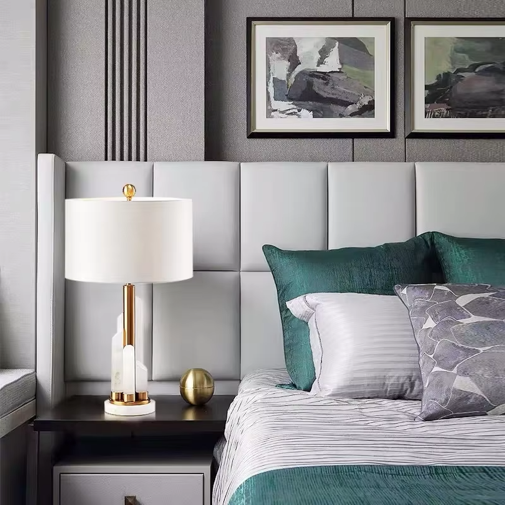 Light luxury white shade gold decorative marble base table lamp, white fabric lampshade + golden metal decorations + white marble base, soft lighting, creating a high-end elegant atmosphere.