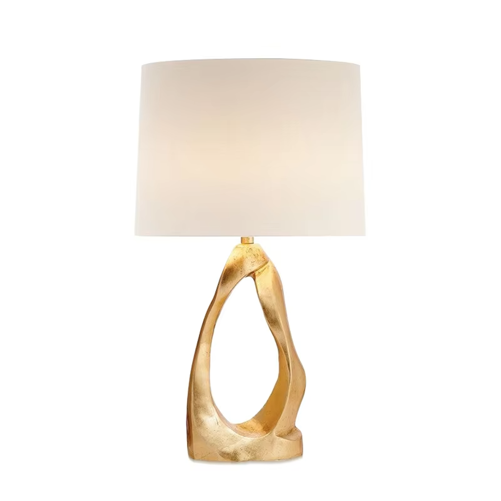 Art light luxury golden irregular twisted hollow base table lamp, beige fabric cylindrical lampshade, soft warm light, creating a high-end art light luxury atmosphere.