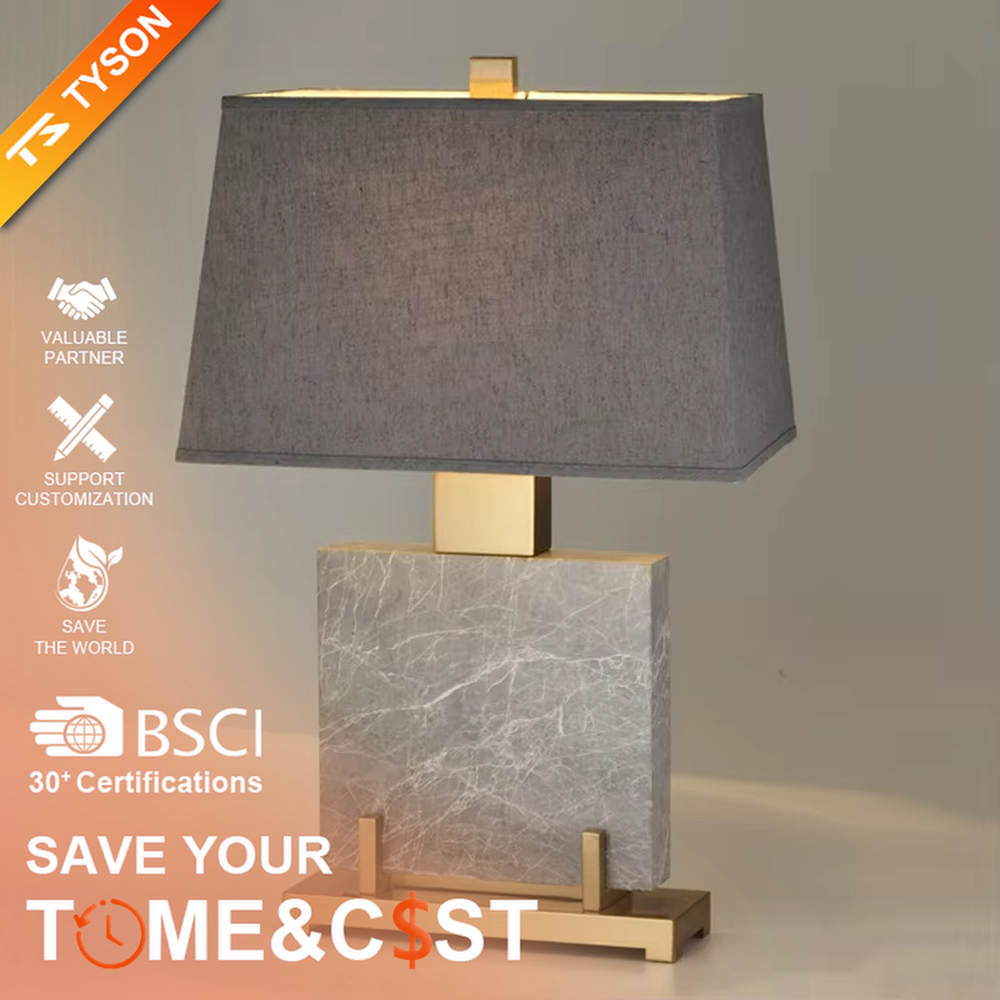 This is a light luxury modern-style marble metal fabric table lamp, with a gray marble base paired with golden metal brackets and connectors, and a gray fabric square lampshade. It features a minimalist and grand design with high texture. It is used for local desktop lighting and decoration, creating a light luxury and elegant atmosphere. Suitable for light luxury-style bedroom bedside tables, modern minimalist living room side tables, high-end hotel guest rooms and other places.