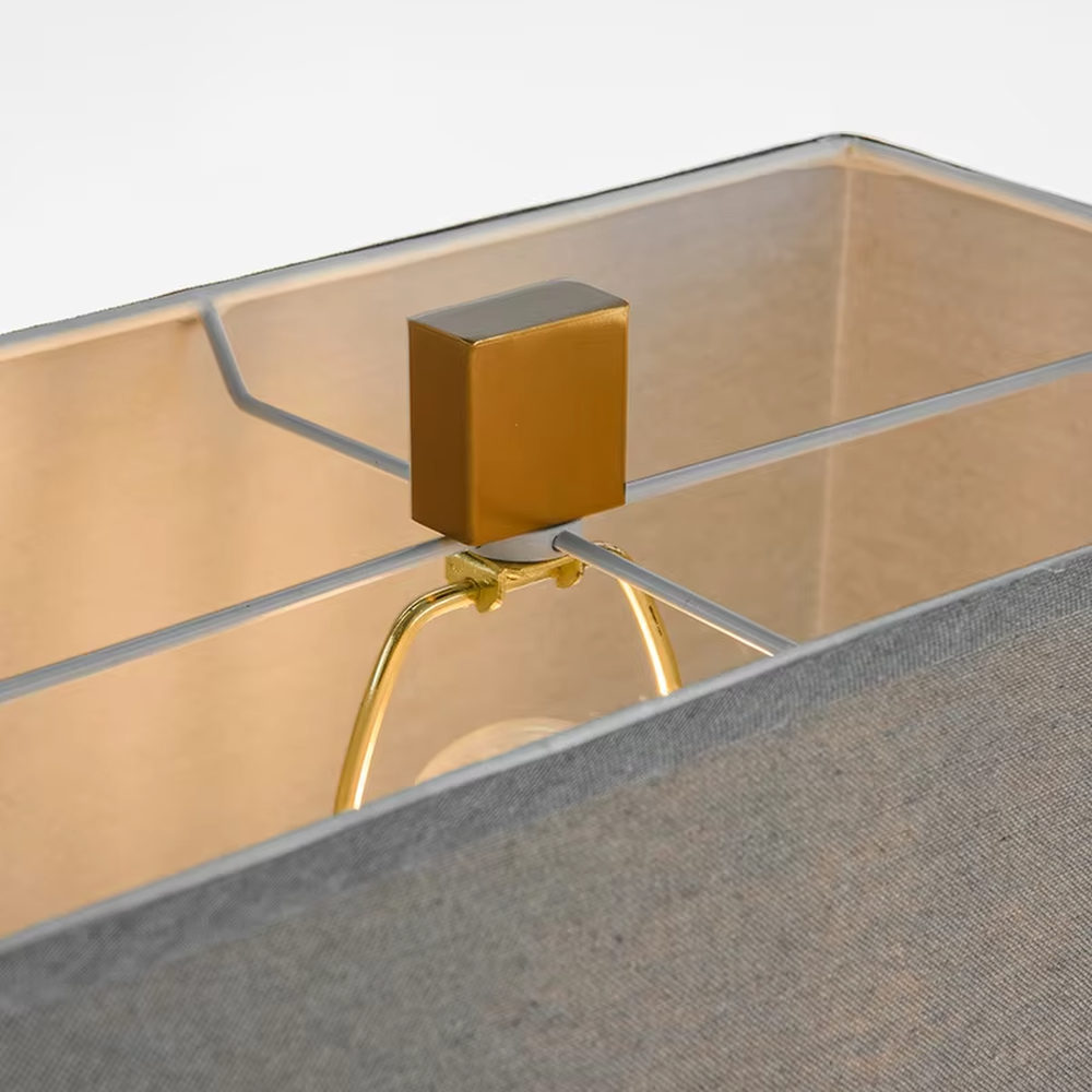 This is a light luxury modern-style marble metal fabric table lamp, with a gray marble base paired with golden metal brackets and connectors, and a gray fabric square lampshade. It features a minimalist and grand design with high texture. It is used for local desktop lighting and decoration, creating a light luxury and elegant atmosphere. Suitable for light luxury-style bedroom bedside tables, modern minimalist living room side tables, high-end hotel guest rooms and other places.