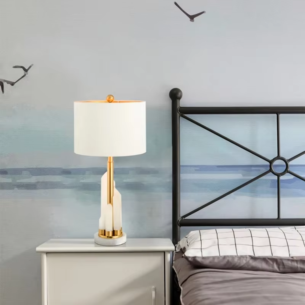 Light luxury white shade gold decorative marble base table lamp, white fabric lampshade + golden metal decorations + white marble base, soft lighting, creating a high-end elegant atmosphere.
