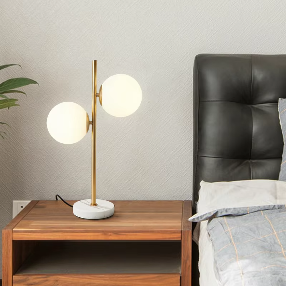 This is a modern light luxury double-ball table lamp, with a golden lamp pole paired with frosted white ball lampshades and a white marble base. The style is simple and exquisite, with soft and warm lighting.