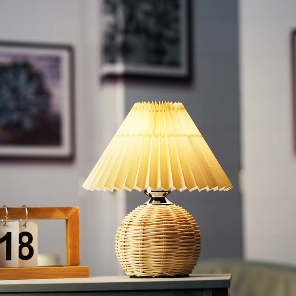 Natural minimalist rattan spherical table lamp, yellow pleated fabric lampshade paired with silver metal decorations, soft and warm lighting, creating a natural and comfortable space atmosphere.