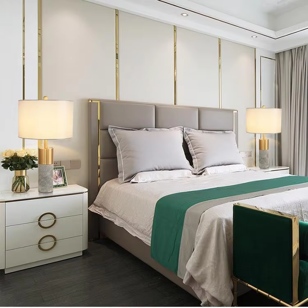 Light luxury gold-decor white marble cylindrical base table lamp, beige fabric cylindrical lampshade, soft warm light, creating a simple high-end light luxury atmosphere.