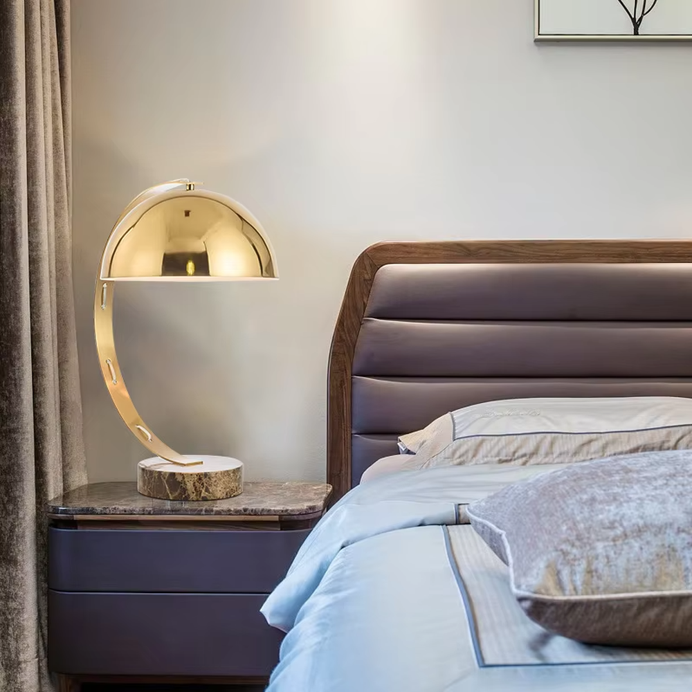 Light luxury golden curved hemisphere table lamp, marble-patterned round base, soft and warm lighting, creating a high-end elegant space atmosphere.