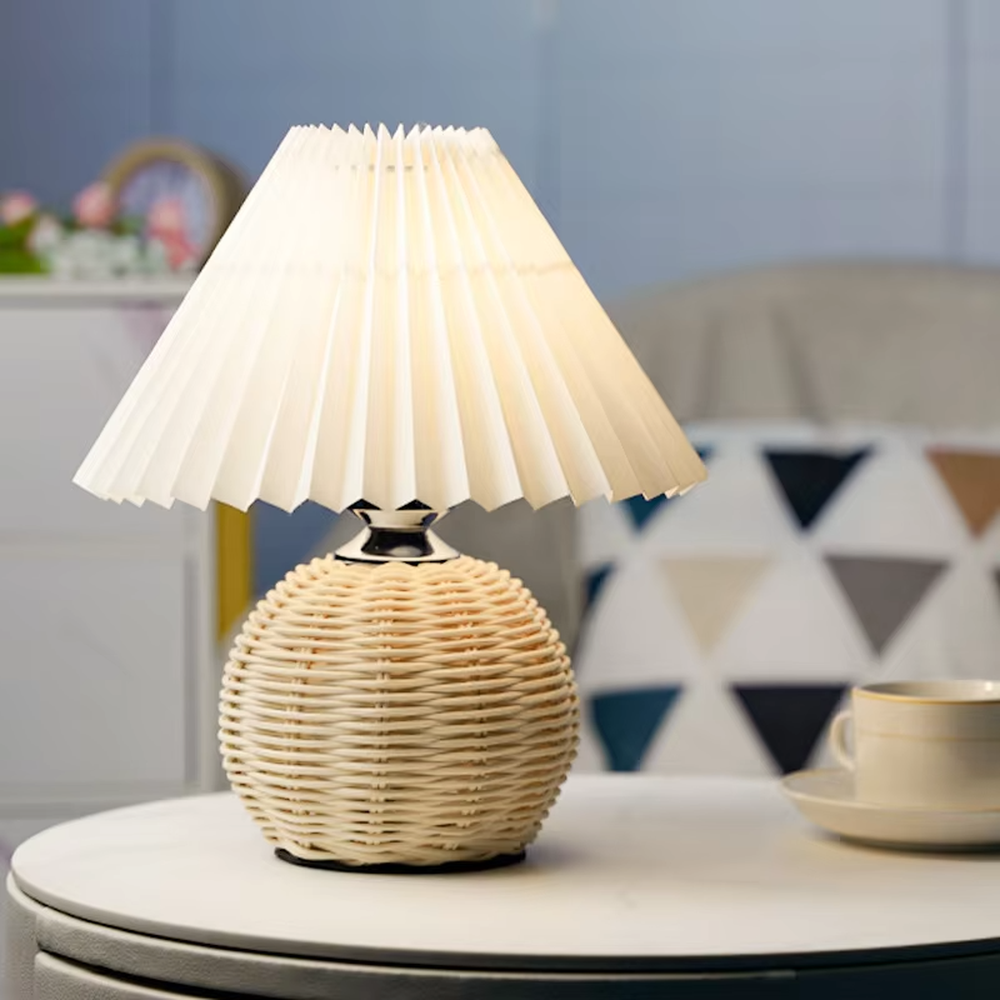 Natural minimalist rattan spherical table lamp, yellow pleated fabric lampshade paired with silver metal decorations, soft and warm lighting, creating a natural and comfortable space atmosphere.