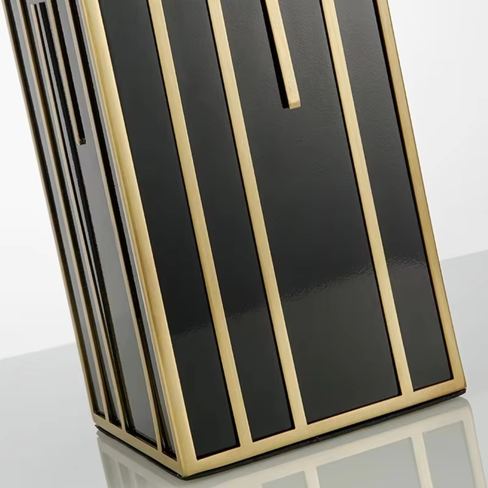 This is a luxury geometric - shaped table lamp with a black - gold geometric base (decorated with gold lines) and a white cylindrical fabric lampshade, featuring a minimalist luxury design with strong modern artistic sense. It is used for local desktop lighting and decoration, creating a luxurious and elegant atmosphere. It is suitable for luxury - style home bedroom bedside tables, high - end hotel guest rooms, modern soft decoration display spaces and other places.