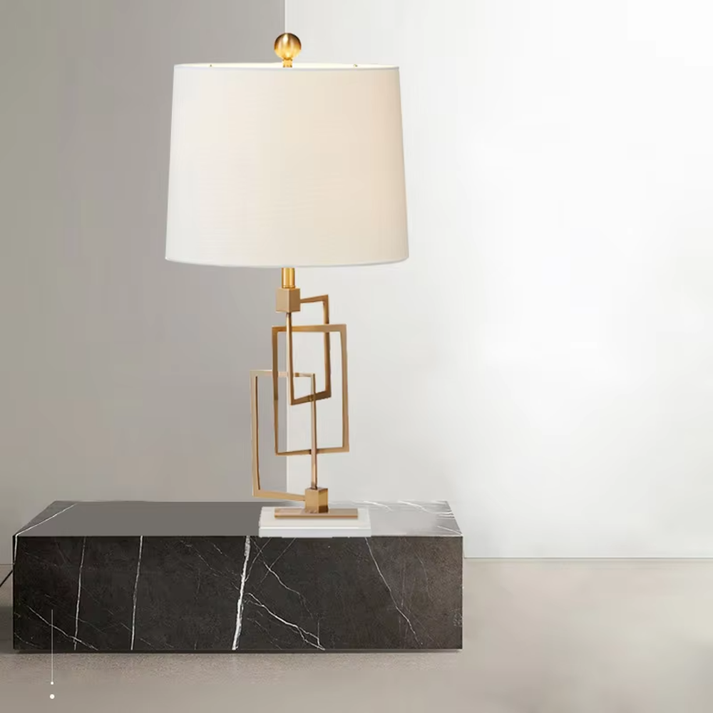 Light luxury modern geometric square frame gold stand table lamp, golden multi-layer square frame stand + beige fabric cylindrical lampshade + white stone base, soft and high-end lighting, creating a light luxury minimalist atmosphere.