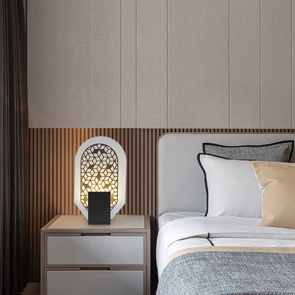 This is an artistic geometric hollow arch table lamp, with an arched hollow design (hexagonal geometric pattern), available in styles like white and orange, paired with different material bases. It features strong artistic sense, and the light forms unique light and shadow through the hollow. It is used for local desktop lighting and decoration, creating an artistic and warm atmosphere. Suitable for art exhibition halls, corners of modern home studies, designer studios and other places.