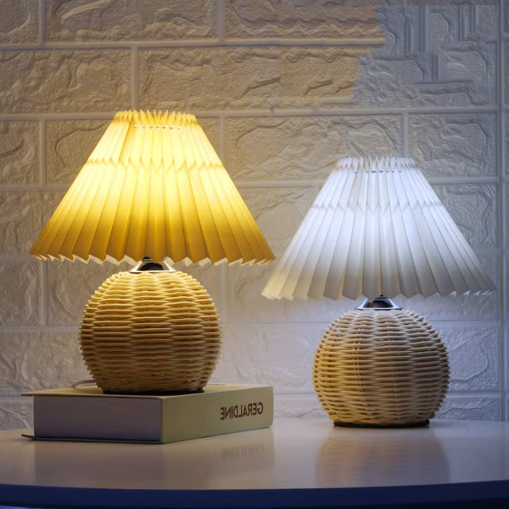 Natural minimalist rattan spherical table lamp, yellow pleated fabric lampshade paired with silver metal decorations, soft and warm lighting, creating a natural and comfortable space atmosphere.