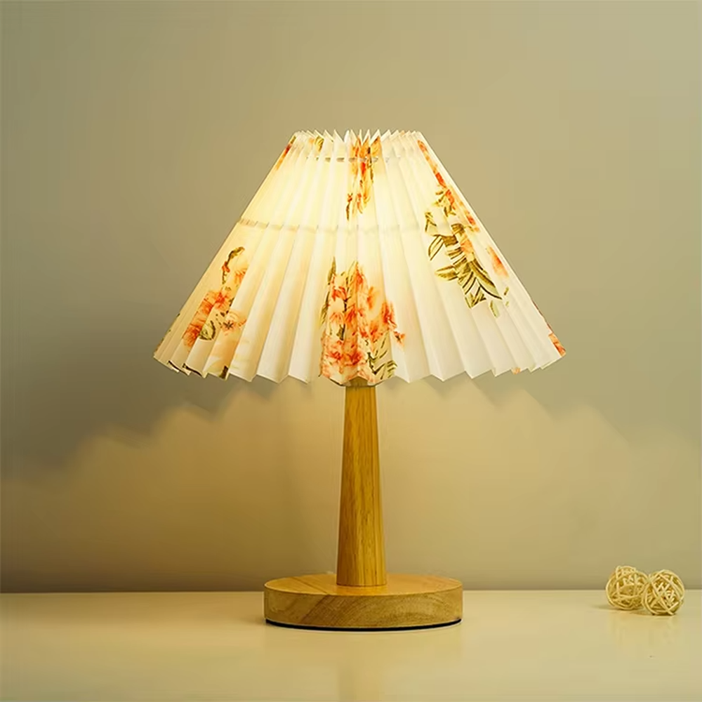 Pastoral fresh-style wooden floral pleated table lamp, wooden lamp pole + base paired with floral-patterned pleated fabric lampshade, soft and warm lighting, creating a natural elegant atmosphere.