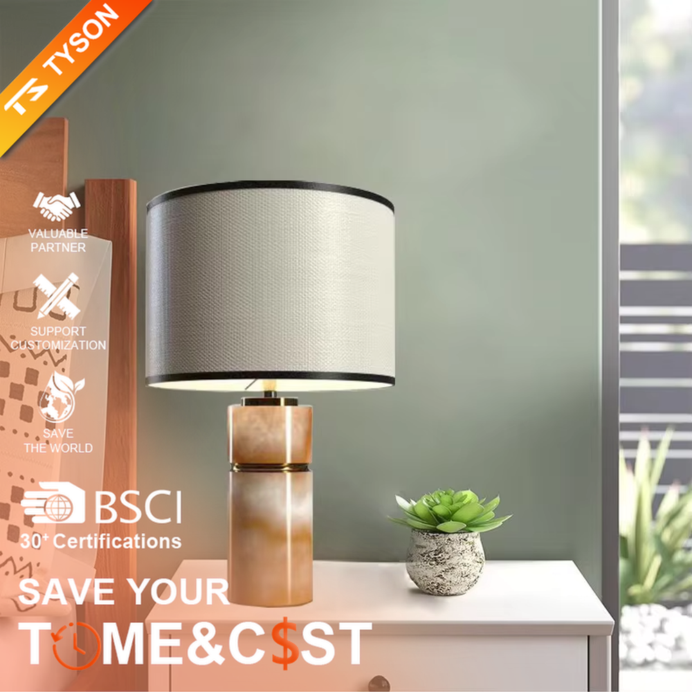 This is a light luxury minimalist table lamp, with a beige textured fabric lampshade (embellished with black trim) paired with a copper-gold layered texture base. It has an elegant and high-end style, with soft and warm lighting, creating a light luxury minimalist atmosphere.