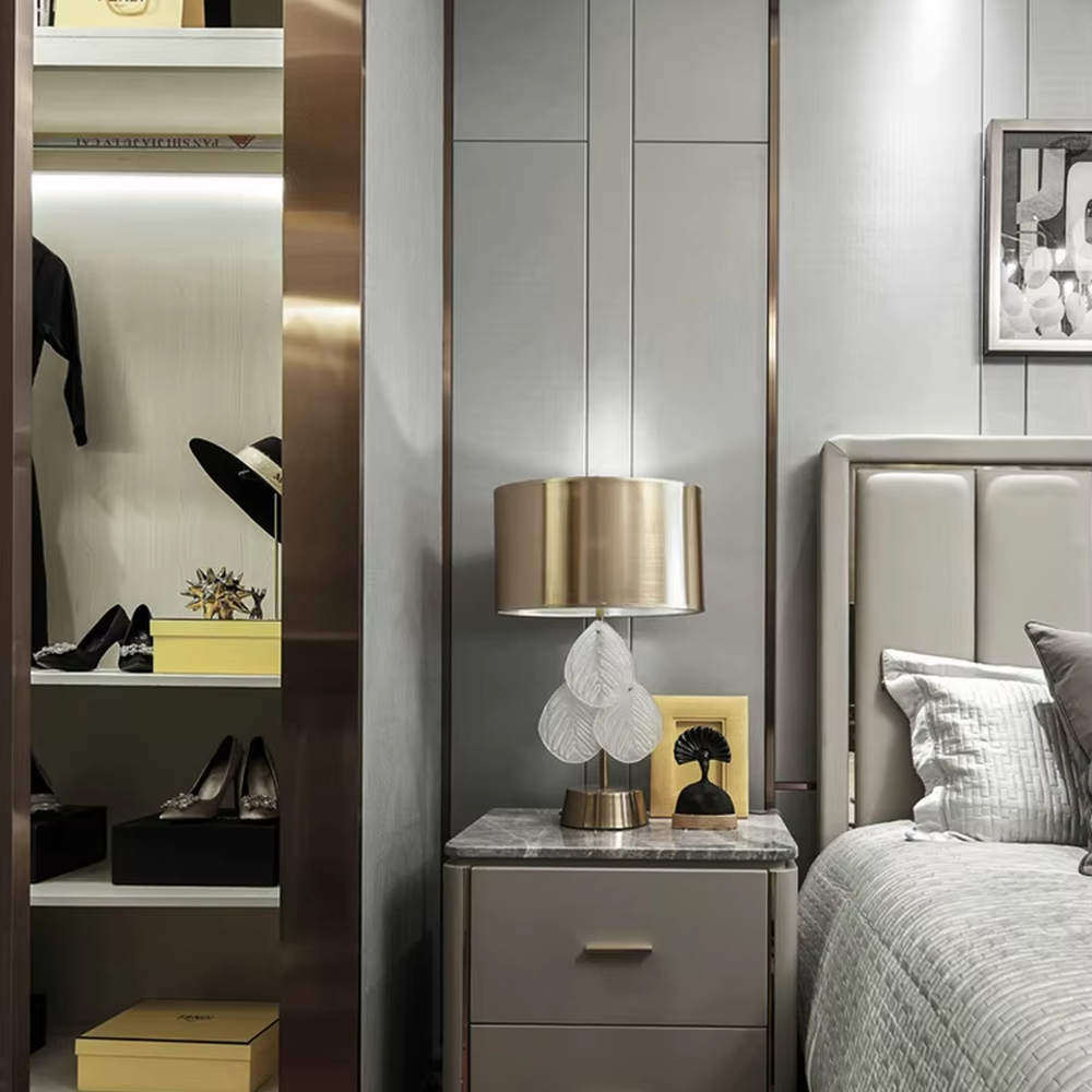 This is a light luxury artistic-style gold and white leaf-decorated table lamp, with a golden metal lampshade and base, paired with transparent leaf-shaped decorations (with texture). It features an exquisite light luxury design, with warm and soft lighting. It is used for local desktop lighting and decoration, creating a light luxury artistic atmosphere. Suitable for light luxury-style bedroom bedside tables, modern minimalist living room side tables, high-end home studies and other places.