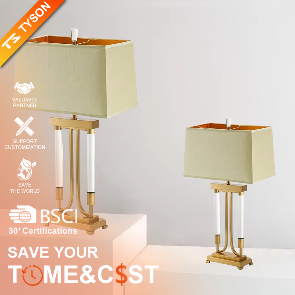 This is a retro elegant-style gold and white fabric table lamp, with a golden metal bracket (with white column elements) and a beige fabric square lampshade (orange interior). It features a retro and exquisite design, with warm and soft lighting. It is used for local desktop lighting and decoration, creating a retro and elegant atmosphere. Suitable for retro-style bedrooms, European-style living rooms, high-end homestays and other places.