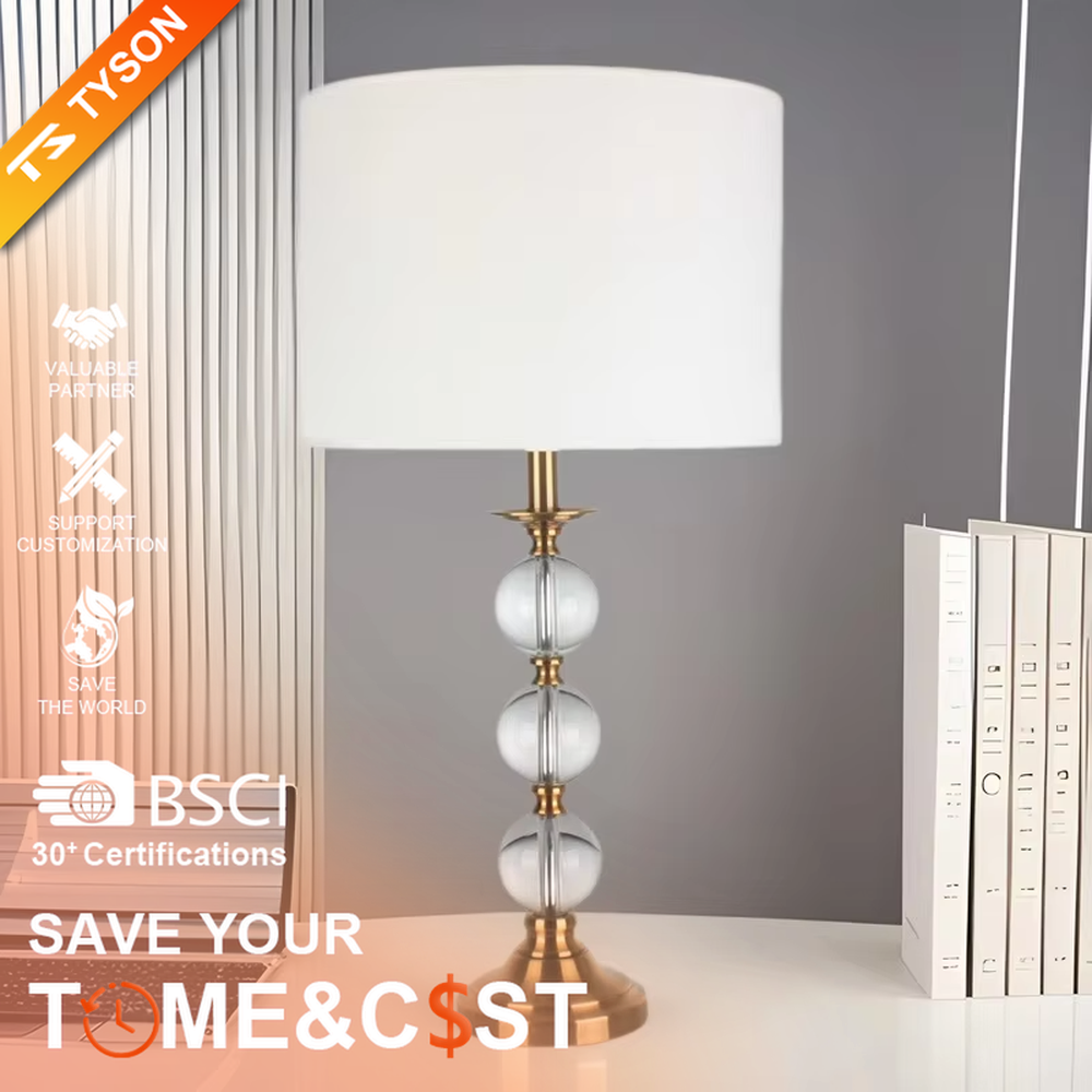 This is a light luxury exquisite crystal ball column table lamp, with a golden metal base and connectors, paired with transparent crystal balls and a white fabric round lampshade. It features a light luxury and exquisite design, with warm and soft lighting. It is used for local desktop lighting and decoration, creating a light luxury elegant atmosphere. Suitable for light luxury-style bedroom bedside tables, modern minimalist living room side tables, high-end hotel guest rooms and other places.