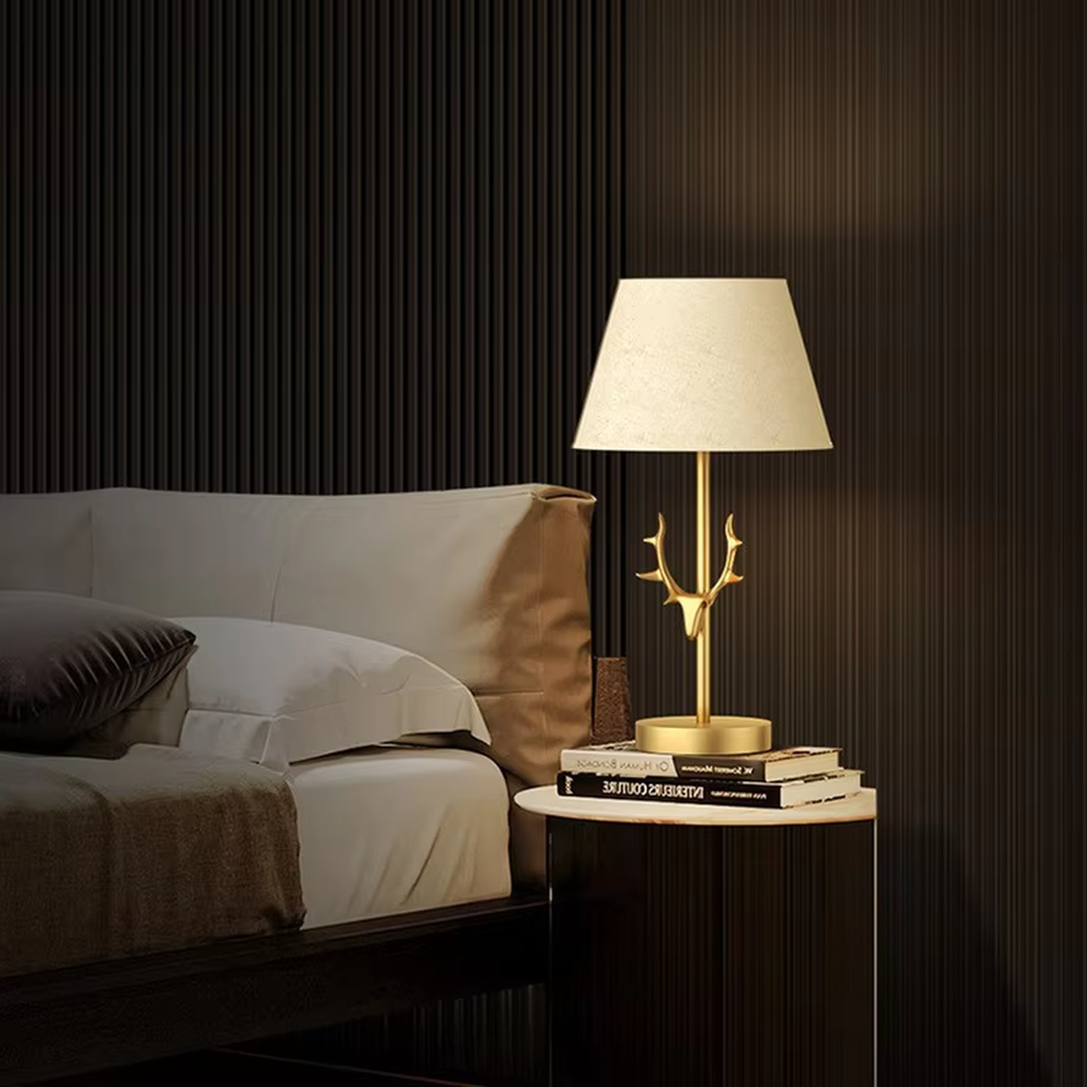 Light luxury golden antler-shaped table lamp, white cylindrical fabric lampshade + golden base, soft and warm lighting, creating a natural elegant atmosphere.