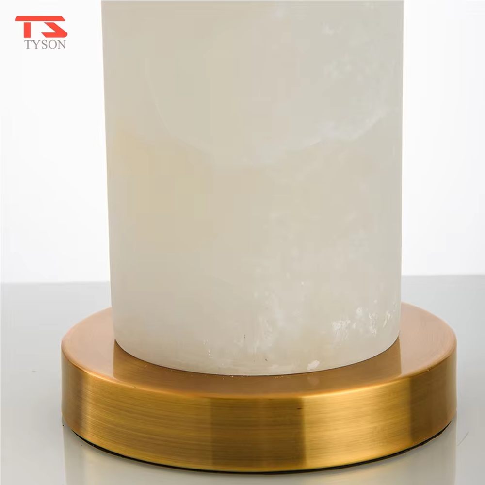 This is a light luxury minimalist table lamp, featuring a natural marble lamp post paired with gold metal accents and an off-white fabric lampshade. It emits soft and gentle light, serving both lighting and decorative purposes, suitable for bedroom nightstands, hotel guest rooms, light luxury living room side tables, showrooms and other scenarios.