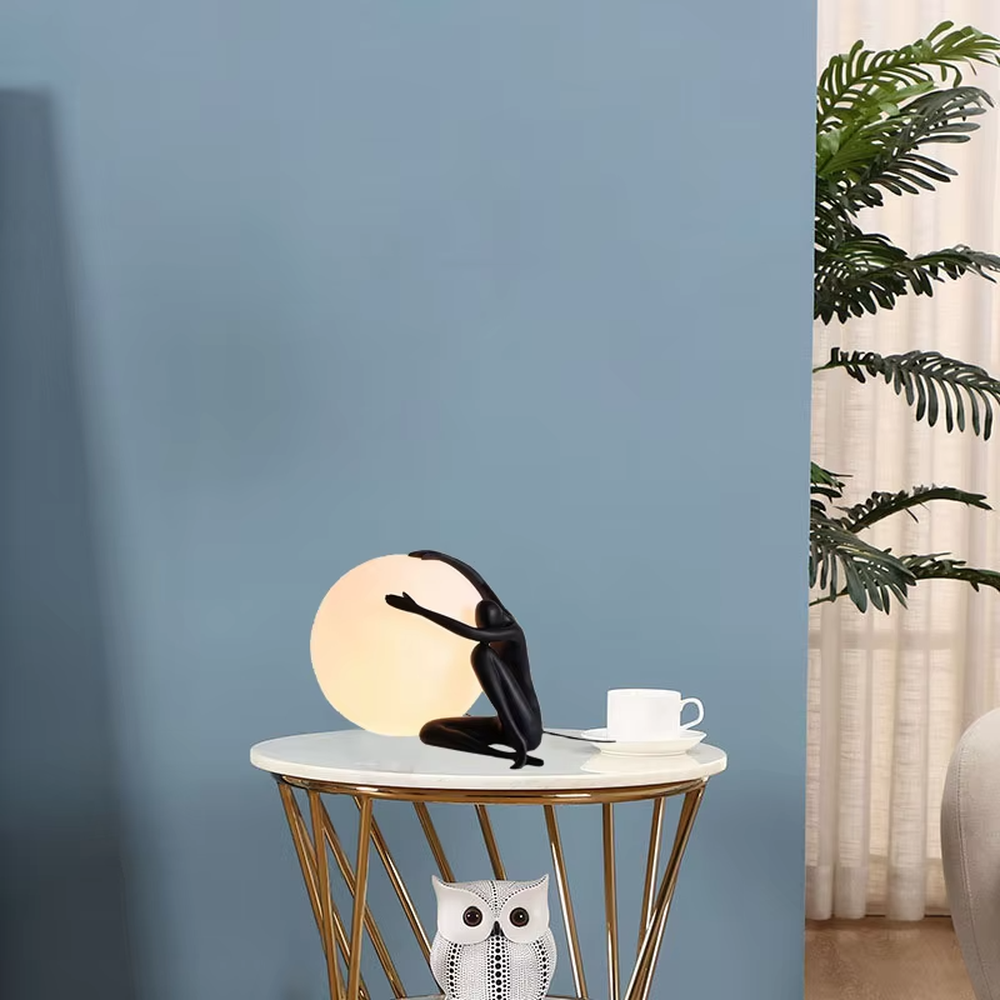 Artistic deep blue humanoid sculpture embracing spherical soft light table lamp, warm light effect, creating a high-end creative artistic space atmosphere.