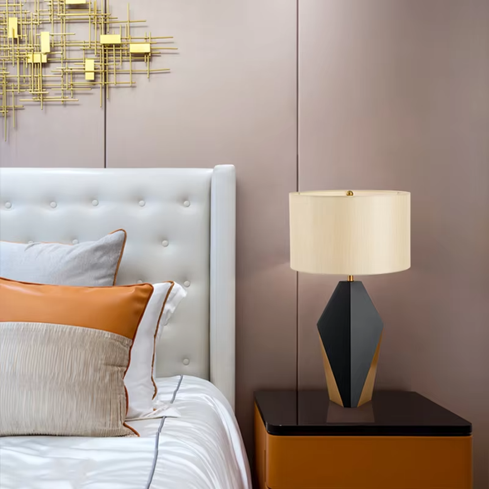 Light luxury black-gold geometric diamond base table lamp, black geometric diamond base + golden decorative details + beige fabric lampshade, soft warm light, creating a high-end light luxury bedroom atmosphere.