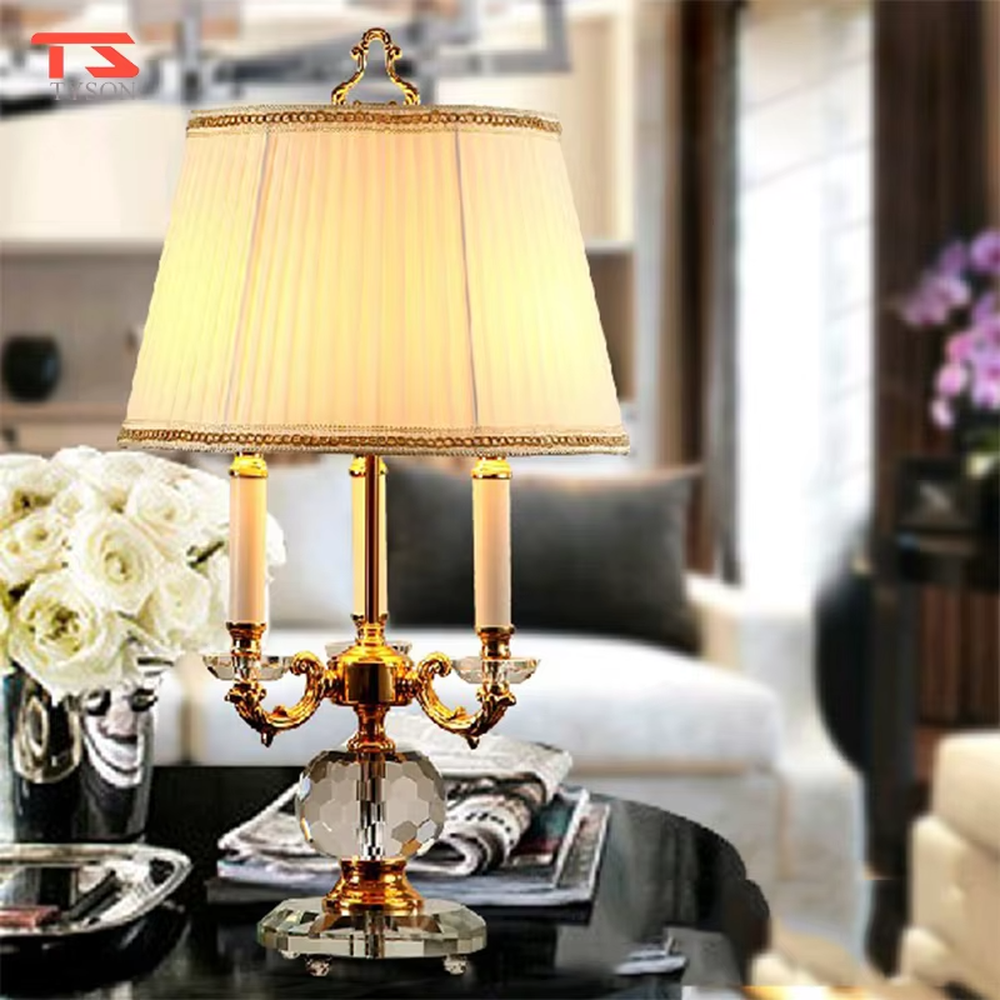 This European court-style table lamp features a carved lamp frame made of glossy gold metal, paired with a crystal ball base and a pleated fabric lampshade (trimmed with gold edging). It presents a luxurious and retro texture, with soft and warm light, serving both lighting and decorative purposes, suitable for European-style bedrooms, villa guest rooms and other spaces.